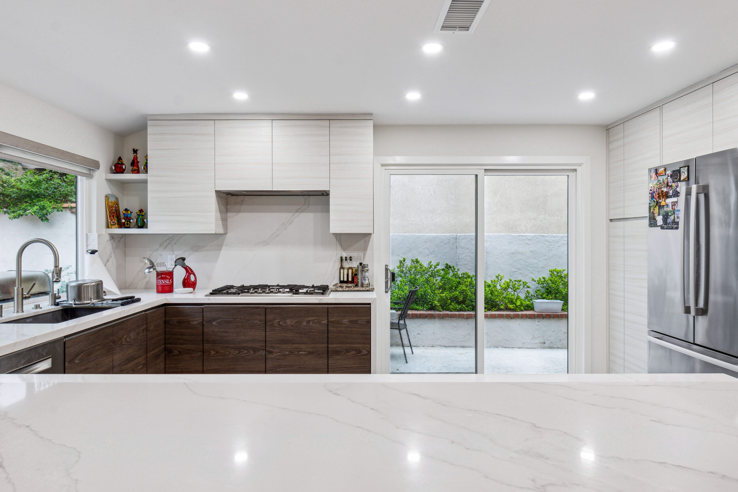 This kitchen features a white quartz countertop and white and dark brown cabinets.